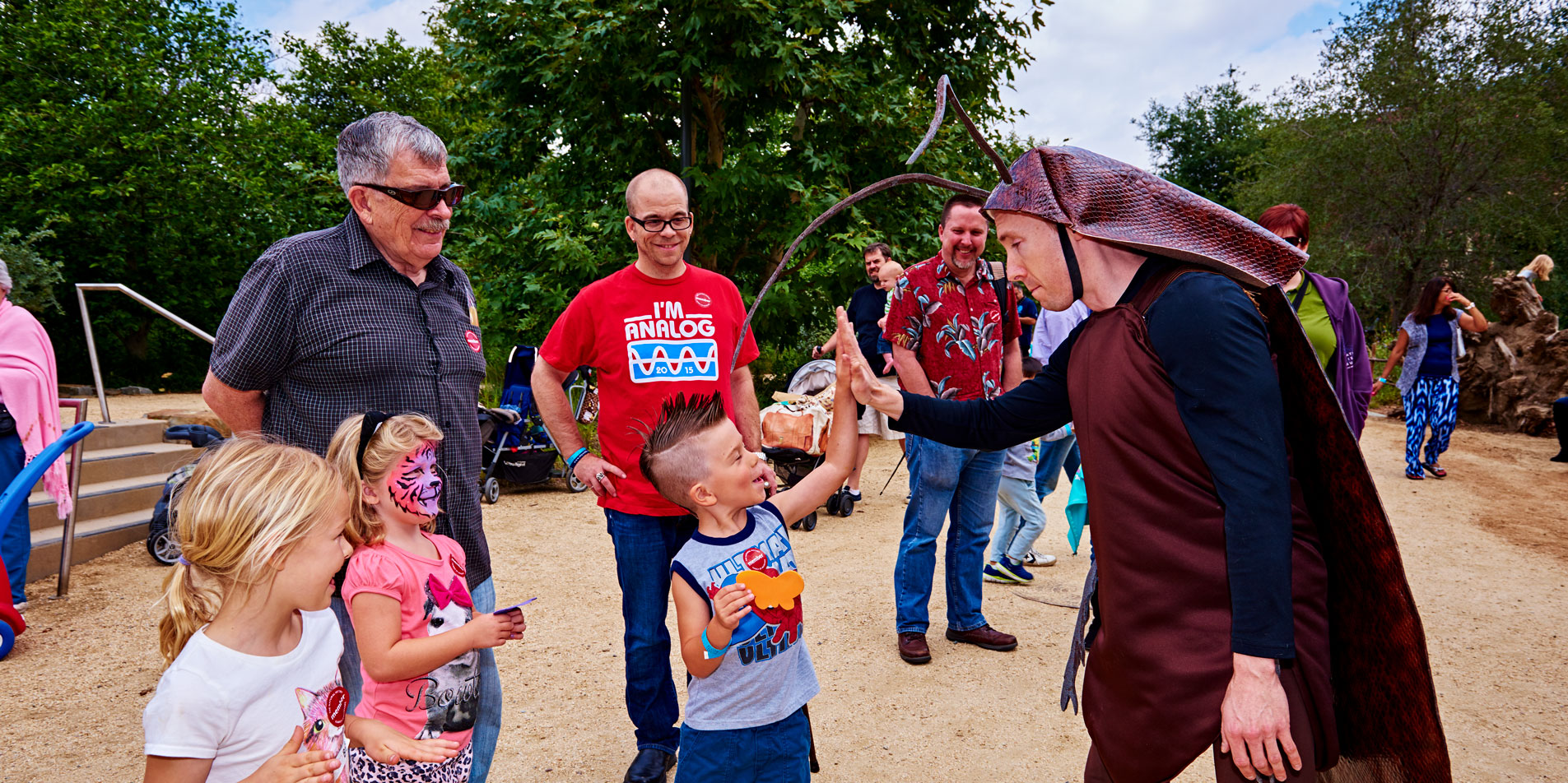 event with children and a staff in a bug costume